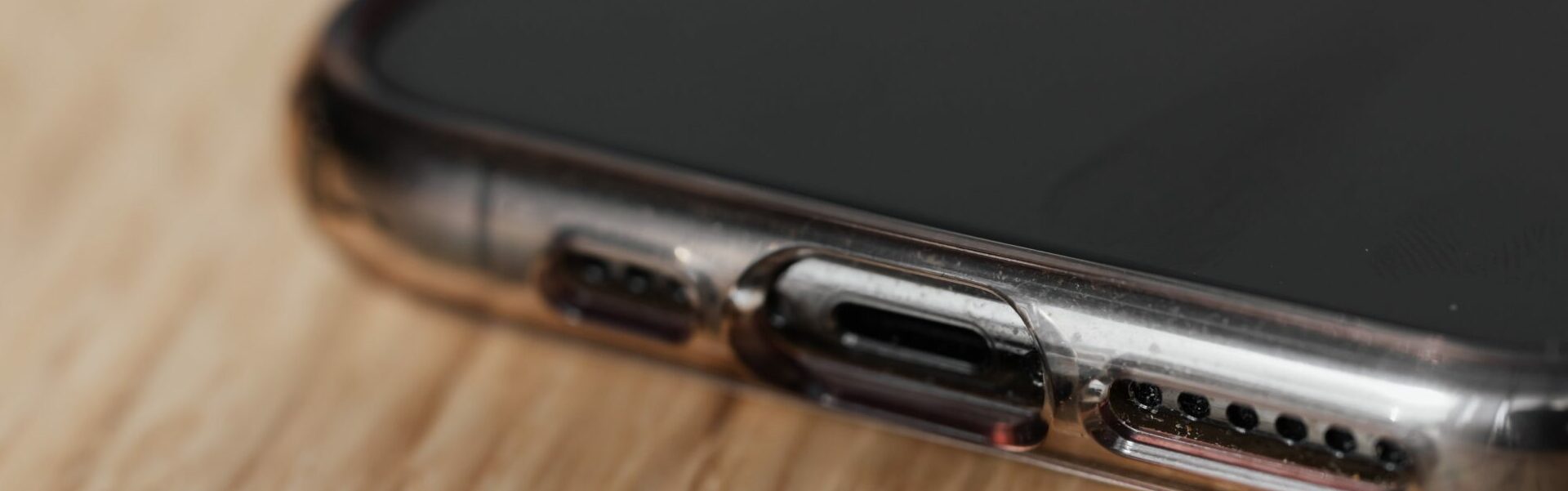 Close-up of a smartphone with a broken charging port.
